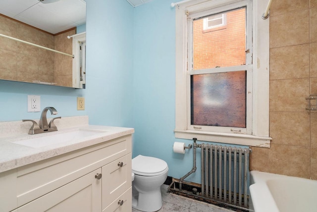 full bathroom with vanity, tile patterned floors, tiled shower / bath combo, toilet, and radiator heating unit