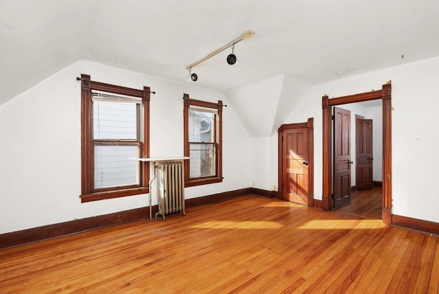 bonus room featuring lofted ceiling, wood-type flooring, and radiator