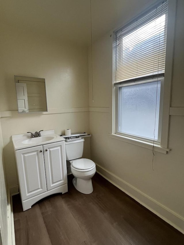 bathroom featuring a wealth of natural light, toilet, vanity, and hardwood / wood-style flooring