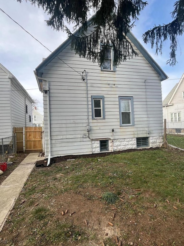 rear view of property featuring a lawn