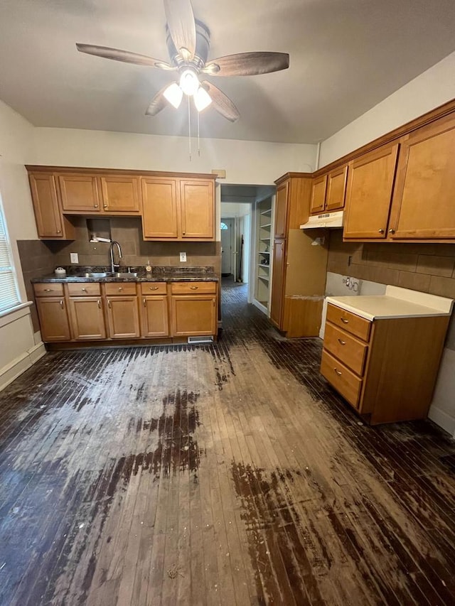 kitchen with decorative backsplash, ceiling fan, sink, and dark wood-type flooring