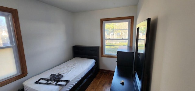 bedroom with dark hardwood / wood-style flooring