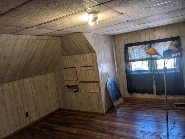 additional living space with lofted ceiling, dark hardwood / wood-style floors, and wooden walls