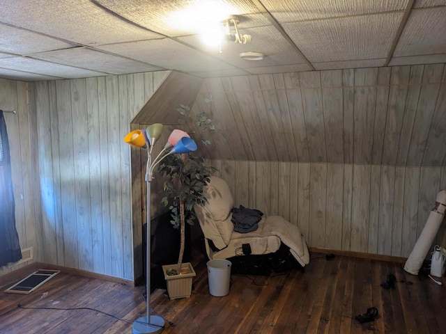 unfurnished room featuring hardwood / wood-style floors, lofted ceiling, and wooden walls