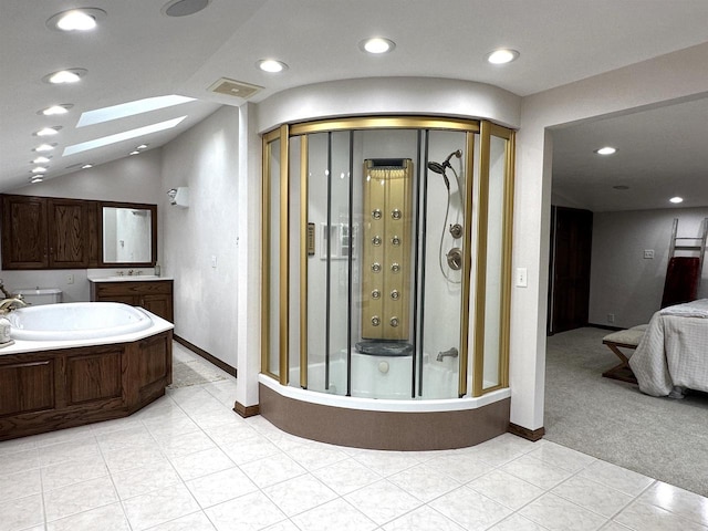 bathroom with tile patterned flooring, a shower with shower door, lofted ceiling with skylight, and vanity