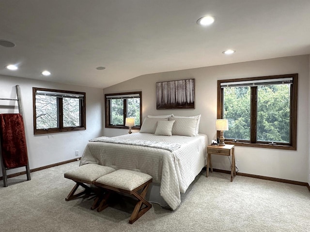 bedroom with carpet flooring, vaulted ceiling, and multiple windows