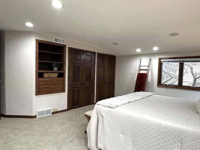 bedroom featuring lofted ceiling and light carpet