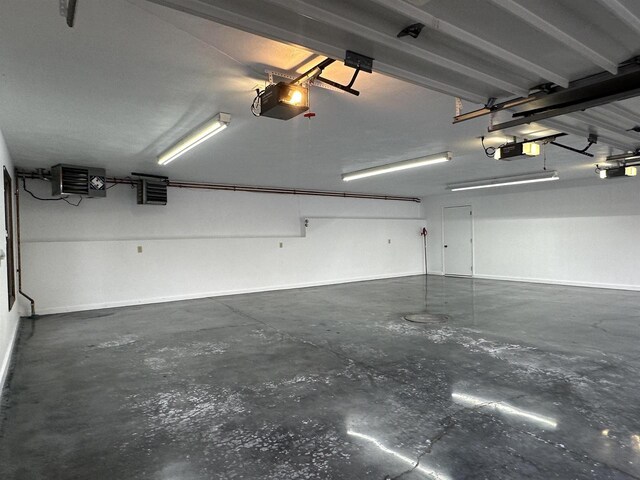 6641 N Kennedy Rd, Milton, WI 53563 - garage featuring a garage door opener, a heating unit, and baseboards