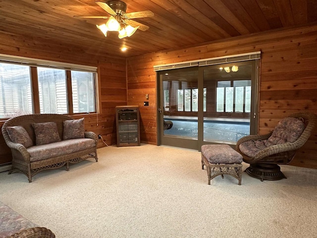 living area featuring carpet floors, a wealth of natural light, wooden walls, and wood ceiling