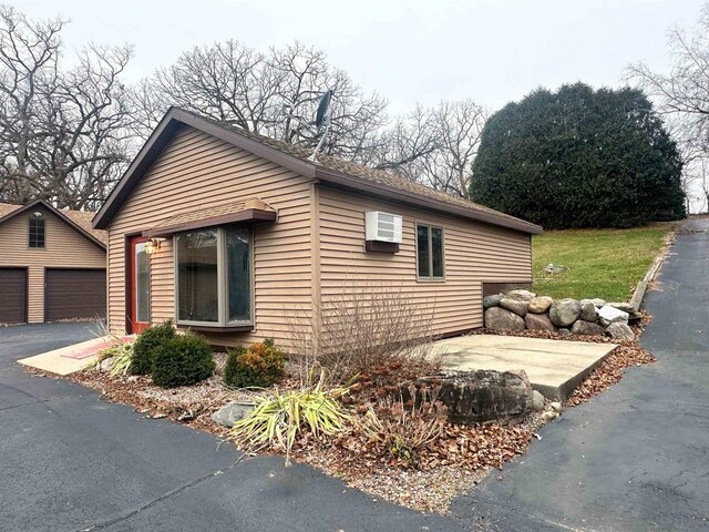 6641 N Kennedy Rd, Milton, WI 53563 - view of side of home featuring an outdoor structure and a wall unit AC