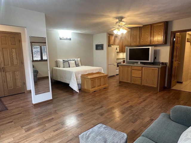 bedroom with ceiling fan, hardwood / wood-style floors, and white fridge