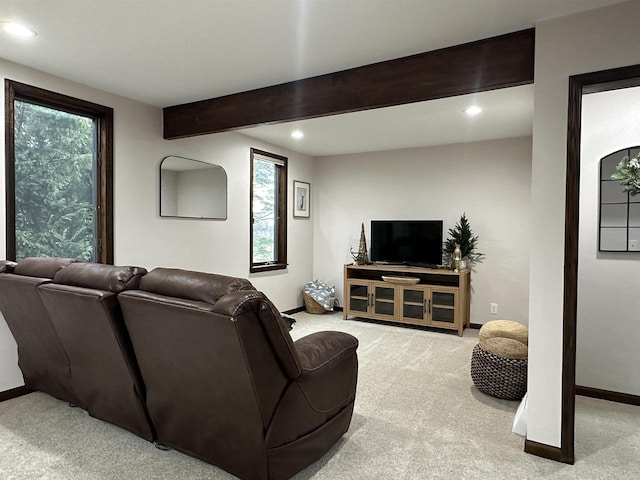 living room featuring carpet flooring, beam ceiling, and a wealth of natural light