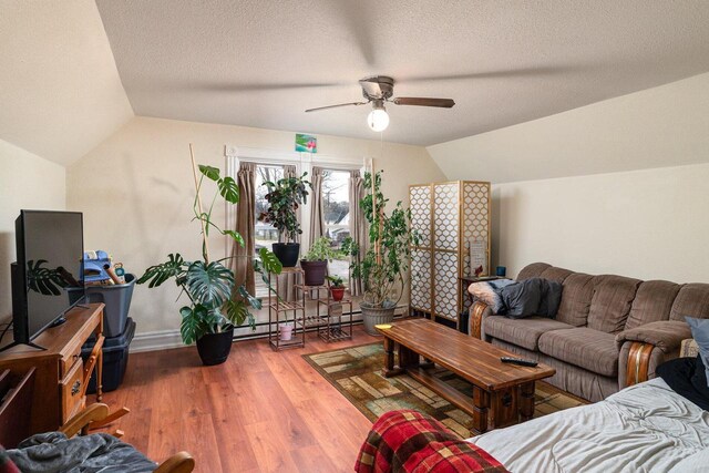 130 W Maple St, Viroqua, WI 54665 - living area featuring lofted ceiling, a ceiling fan, wood finished floors, and a textured ceiling