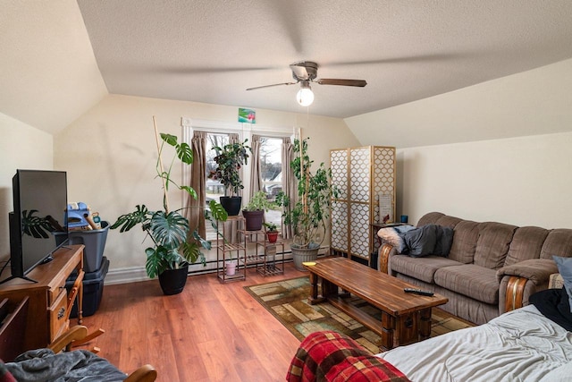 130 W Maple St, Viroqua, WI 54665 - living area with lofted ceiling, ceiling fan, wood finished floors, baseboards, and a textured ceiling