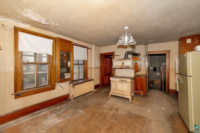 kitchen featuring stainless steel fridge, pendant lighting, radiator, and a notable chandelier