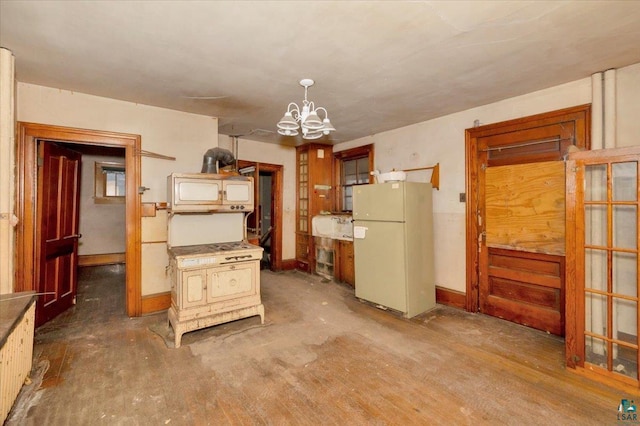 kitchen featuring radiator, an inviting chandelier, white refrigerator, hanging light fixtures, and cream cabinetry