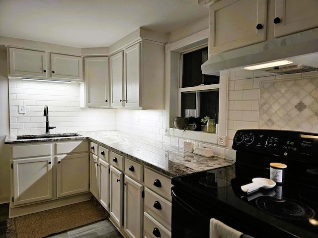 kitchen with backsplash, black / electric stove, sink, and light hardwood / wood-style flooring