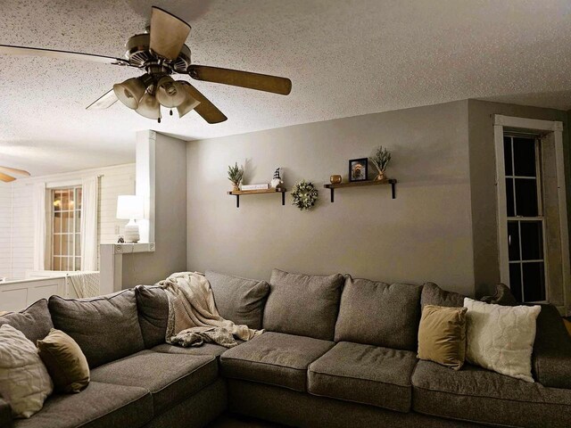 living room featuring a textured ceiling and ceiling fan