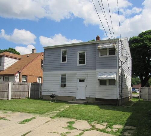 rear view of property with a yard