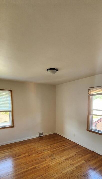 empty room with light hardwood / wood-style flooring