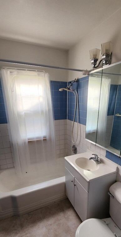 full bathroom featuring vanity, toilet, and tiled shower / bath