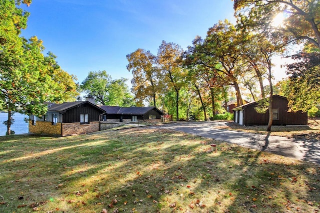 2572 N Shore Dr, Delavan, WI 53115 - view of green lawn featuring a water view, an outbuilding, and driveway