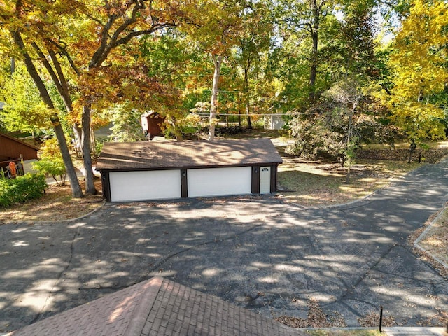 2572 N Shore Dr, Delavan, WI 53115 - view of front of house with a garage, an outbuilding, and view of wooded area