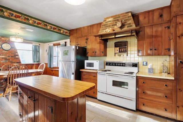 2572 N Shore Dr, Delavan, WI 53115 - kitchen featuring white appliances, brown cabinetry, decorative backsplash, and a kitchen island