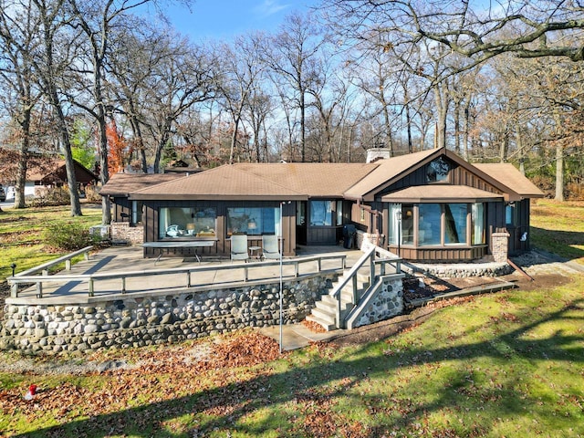 2572 N Shore Dr, Delavan, WI 53115 - back of house featuring a chimney, board and batten siding, roof with shingles, and a lawn
