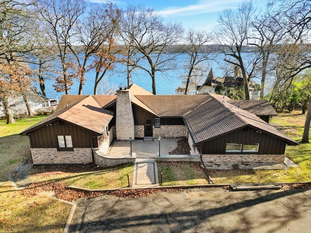 2572 N Shore Dr, Delavan, WI 53115 - view of front of home with board and batten siding, a water view, and a chimney