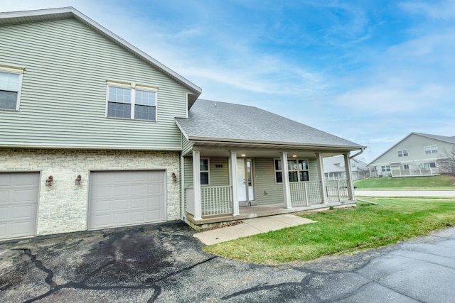 view of front of house featuring a front yard, a porch, and a garage