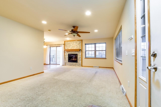 unfurnished living room with light carpet, a fireplace, and ceiling fan