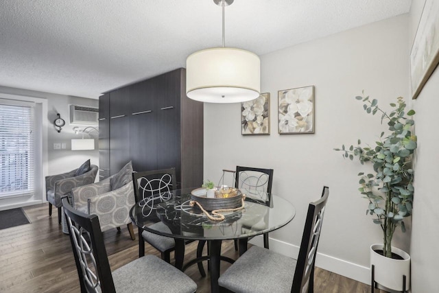 dining area with a wall mounted AC, a textured ceiling, and dark hardwood / wood-style flooring