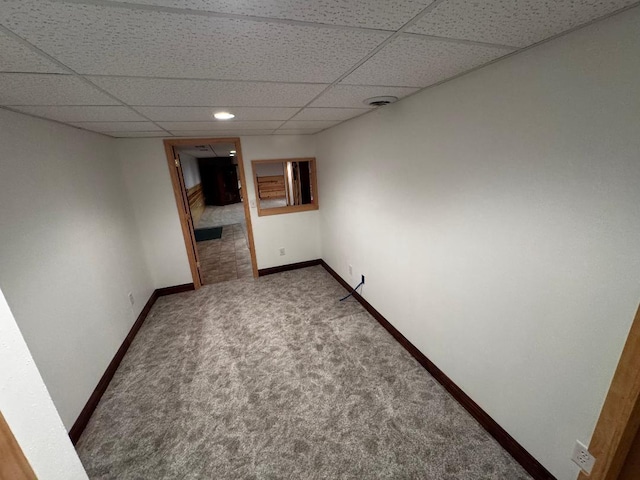 carpeted spare room featuring a paneled ceiling