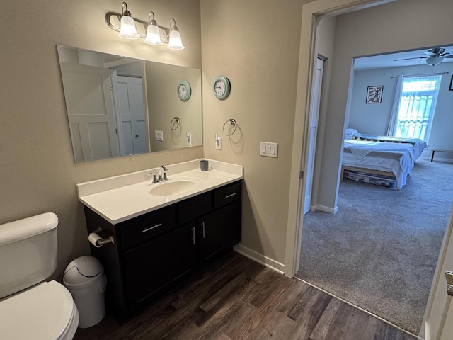 bathroom with ceiling fan, hardwood / wood-style floors, vanity, and toilet