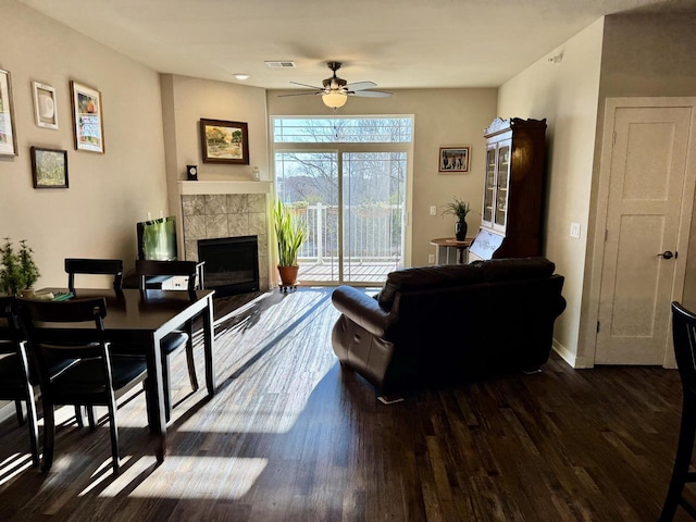 living room with ceiling fan, dark hardwood / wood-style floors, and a fireplace