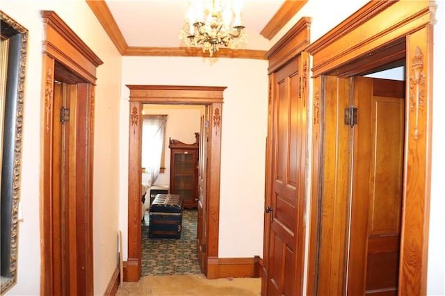 hall with a chandelier, light colored carpet, and ornamental molding