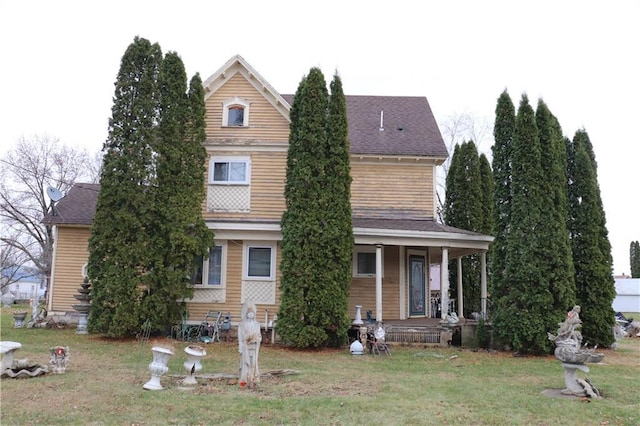 view of front of home with covered porch and a front lawn