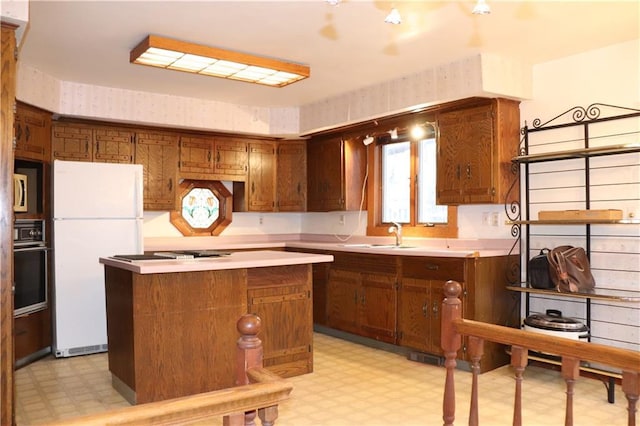 kitchen with sink, a kitchen island, and white appliances