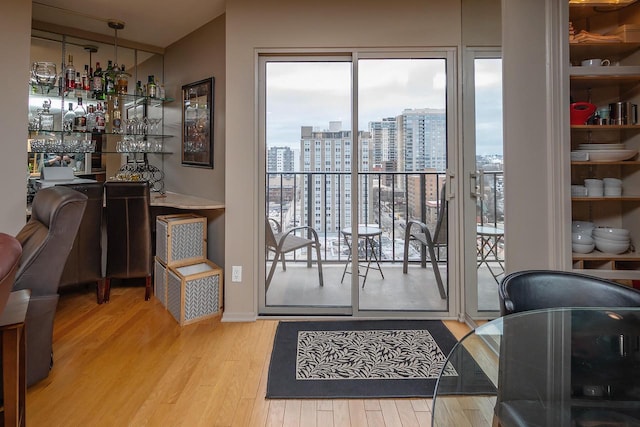 interior space with bar area and light hardwood / wood-style flooring