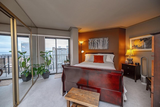 bedroom with access to outside, crown molding, and light colored carpet