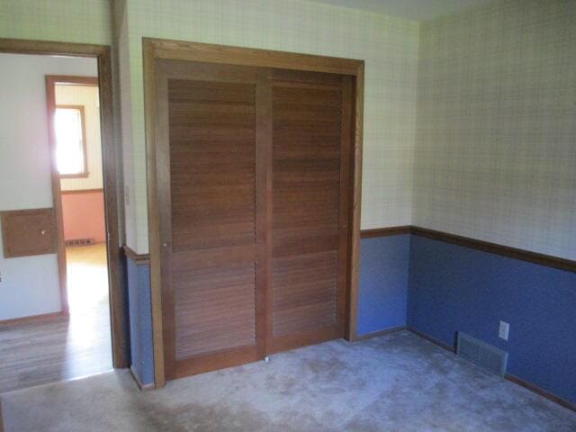 unfurnished bedroom with carpet floors and a closet