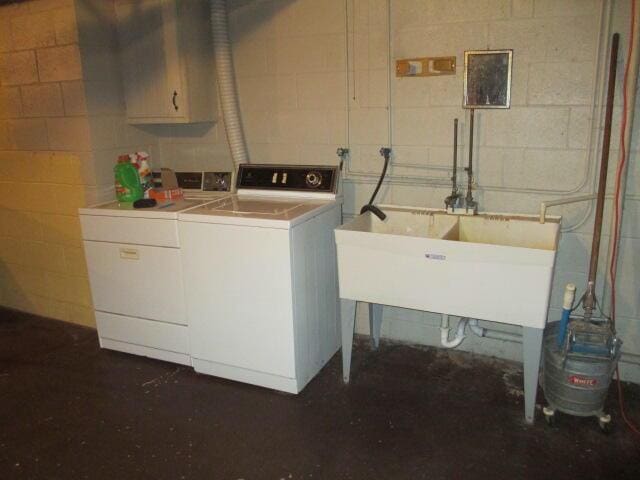 laundry room featuring cabinets, separate washer and dryer, and sink