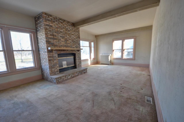 unfurnished living room featuring beamed ceiling, carpet flooring, radiator heating unit, and a fireplace