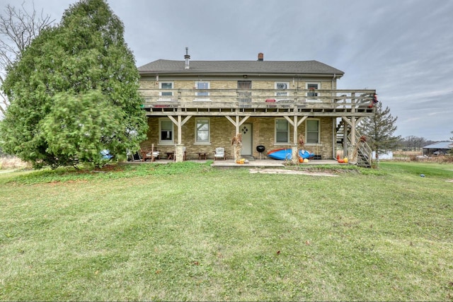 rear view of property with a wooden deck, a yard, and a patio