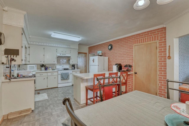 kitchen with ornamental molding, a breakfast bar, white appliances, light parquet floors, and white cabinets