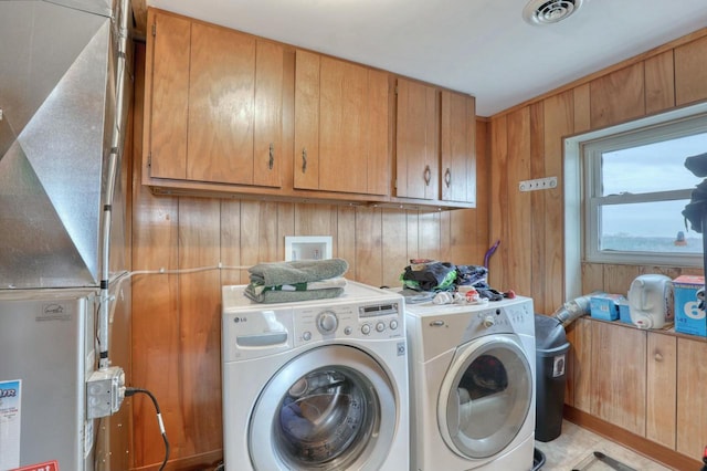 laundry area featuring separate washer and dryer and wood walls