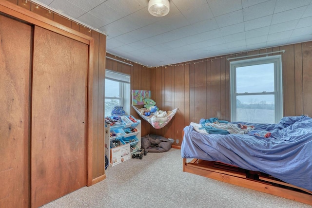 bedroom with wood walls and carpet