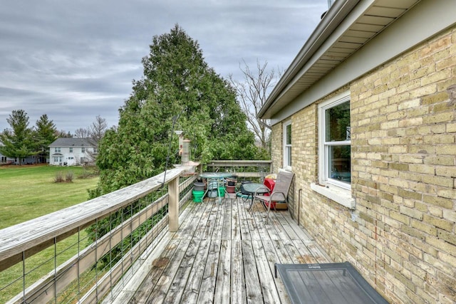 wooden terrace featuring a lawn