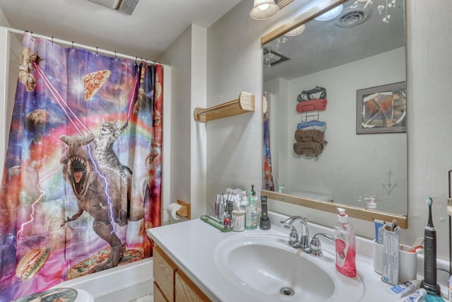 bathroom with walk in shower, vanity, and toilet